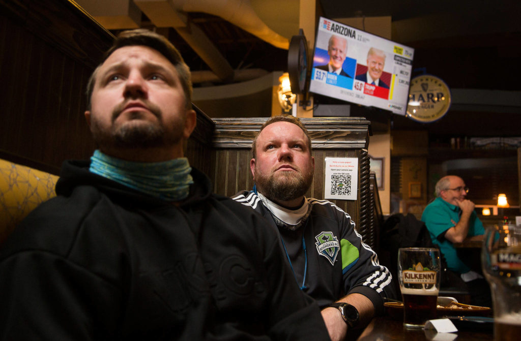Steven Foraker and Brian Harvey watch election returns at Shawn O’Donnell’s American Grill and Irish Pub on Tuesday in Mill Creek. (Andy Bronson / The Herald)

