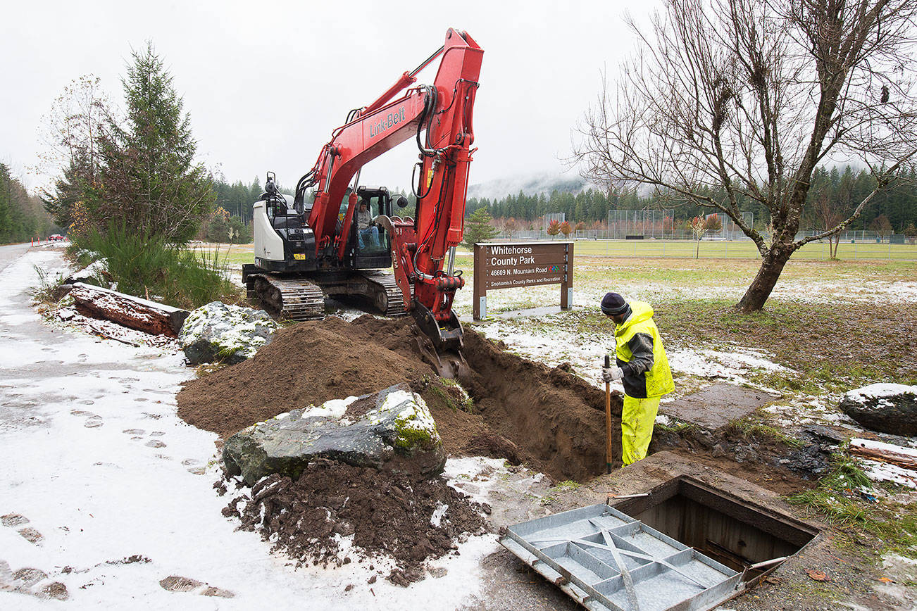 Workers from Konnerup Construction dig to a junction box as construction of RV campsites, and the first equestrian campsites in the county, are being built in Whitehorse County Park on Tuesday, Nov. 10, 2020 in Darrington, Washington.  (Andy Bronson / The Herald)