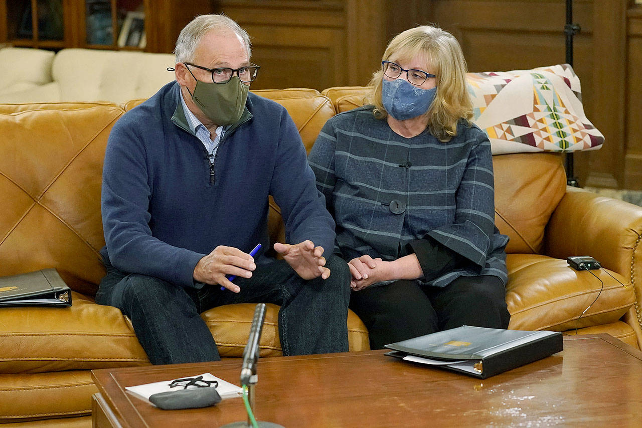 Washington Gov. Jay Inslee and his wife, Trudi, wear masks before taking them off for a rehearsal in the governor’s office before making a statewide televised address on COVID-19 on Thursday. (AP Photo/Ted S. Warren)