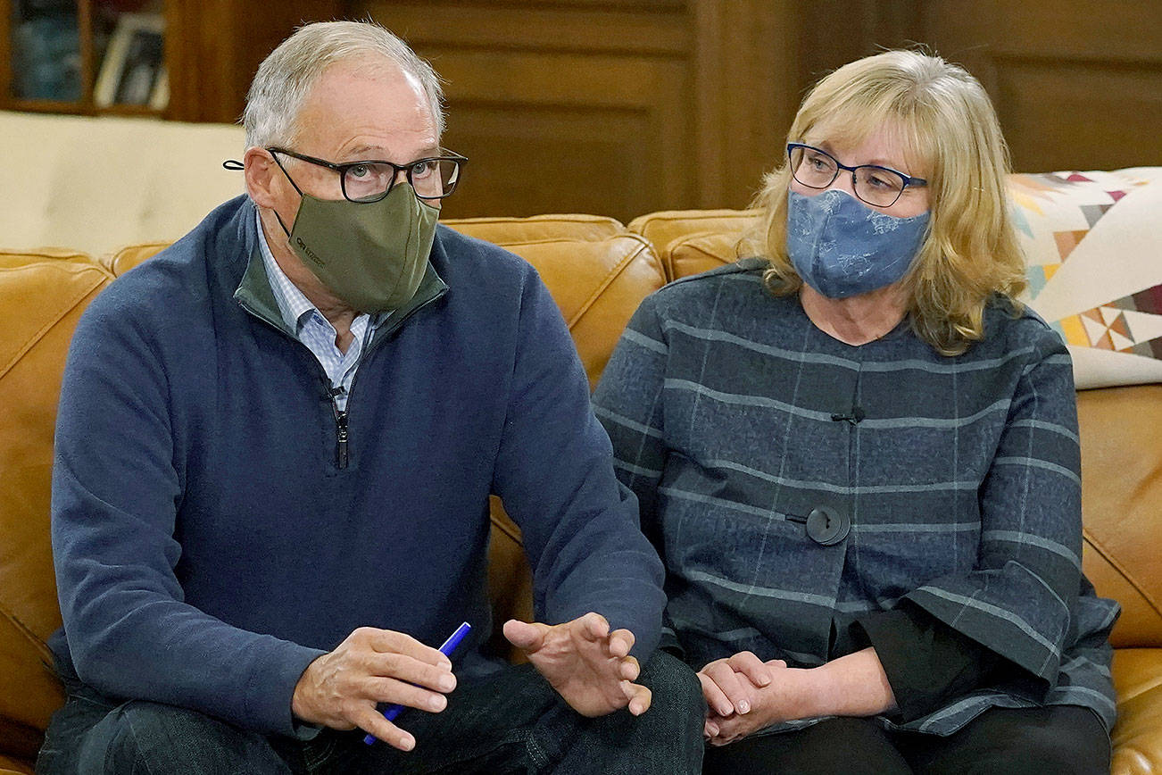 Washington Gov. Jay Inslee and his wife, Trudi, wear masks before taking them off for a final rehearsal in the governor's office before making a statewide televised address on COVID-19, which health officials have warned is accelerating rapidly throughout the state, Thursday, Nov. 12, 2020, at the Capitol in Olympia, Wash. (AP Photo/Ted S. Warren)