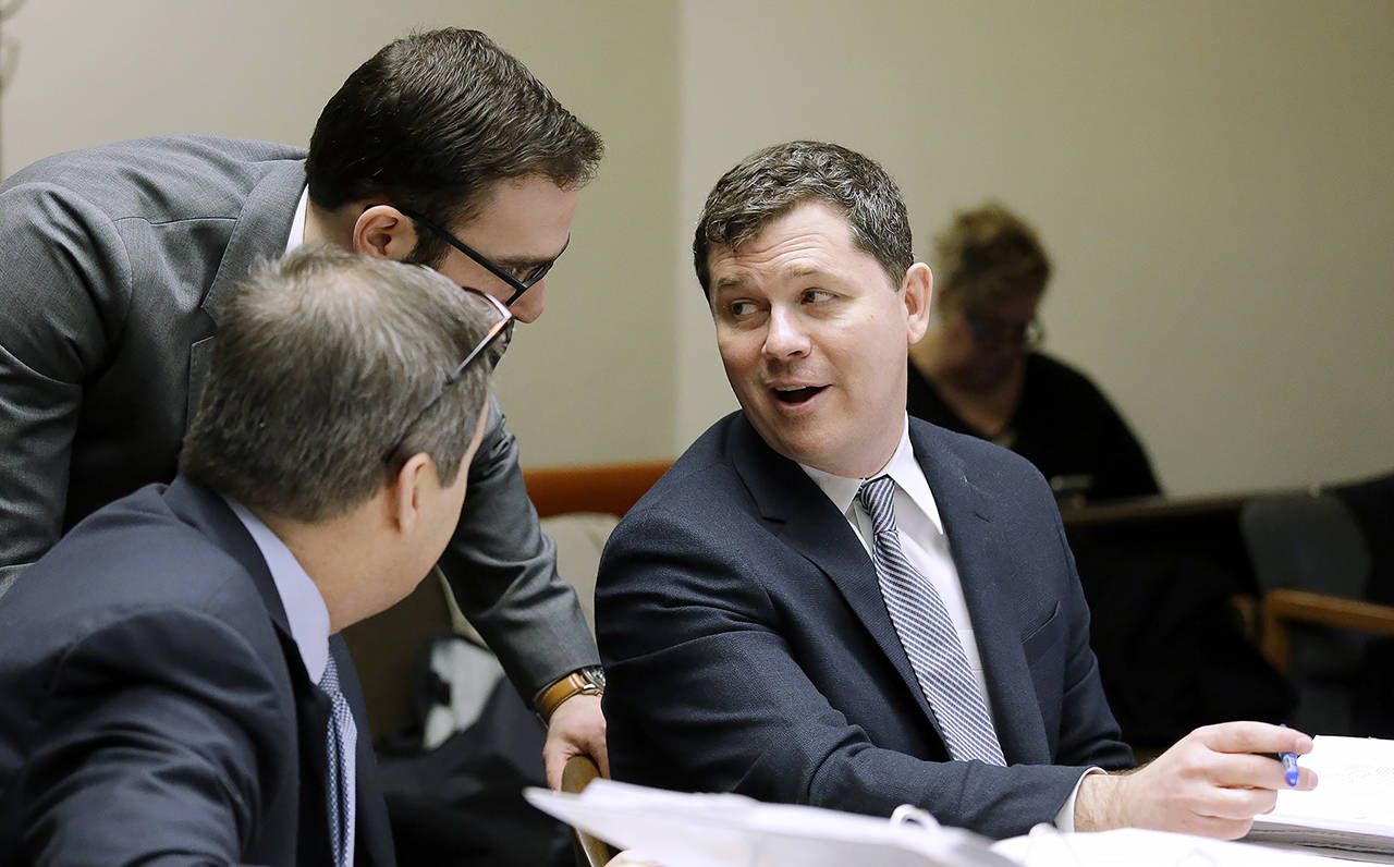 In this 2016 photo, Grocery Manufacturers Association lawyer Matthew Gardner (right) talks with others, before making arguments in a case alleging that the food industry group violated state campaign disclosure laws in opposing a 2013 food labeling initiative, in Olympia. (AP Photo/Elaine Thompson, file)