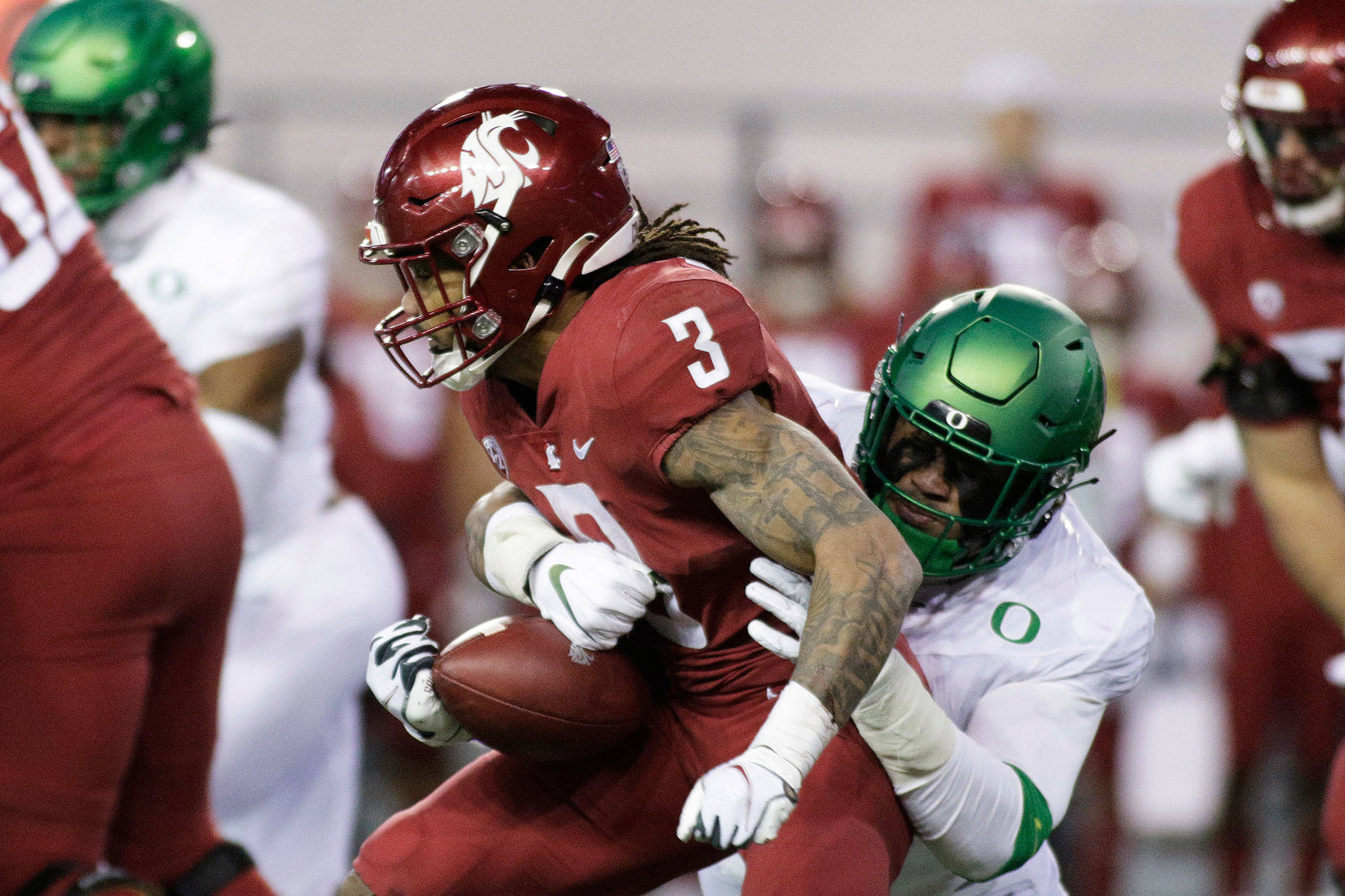 Oregon linebacker Noah Sewell (right) tackles Washington State running back Deon McIntosh during the second half of a game Nov. 14, 2020, in Pullman. (AP Photo/Young Kwak)