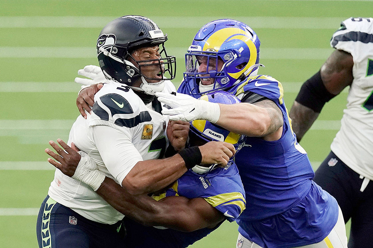 Seattle Seahawks quarterback Russell Wilson (3) is tackled by two against the Los Angeles Rams defenders during the second half of an NFL football game Sunday, Nov. 15, 2020, in Inglewood, Calif. (AP Photo/Jae C. Hong )