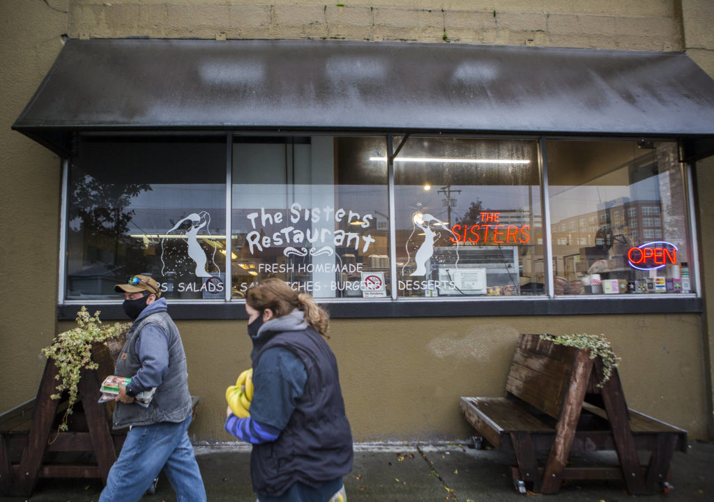 People walk by the outside of Sisters on Tuesday in Everett. (Olivia Vanni / The Herald)
