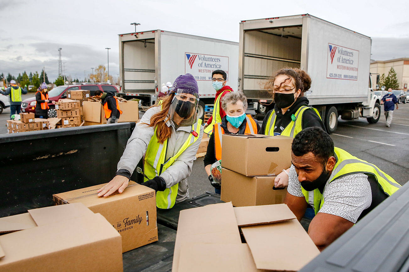 Volunteers of America and Farmer Frog load food stuffs during a drive-thru distribution at Everett Mall Friday November 20, 2020. (Kevin Clark / The Herald)