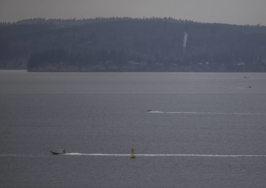 A patrol boat heads across Possession Sound while the search for a Tulalip police officer missing from a capsized Tulalip fisheries boat continues Wednesday near Everett. (Olivia Vanni / The Herald)
