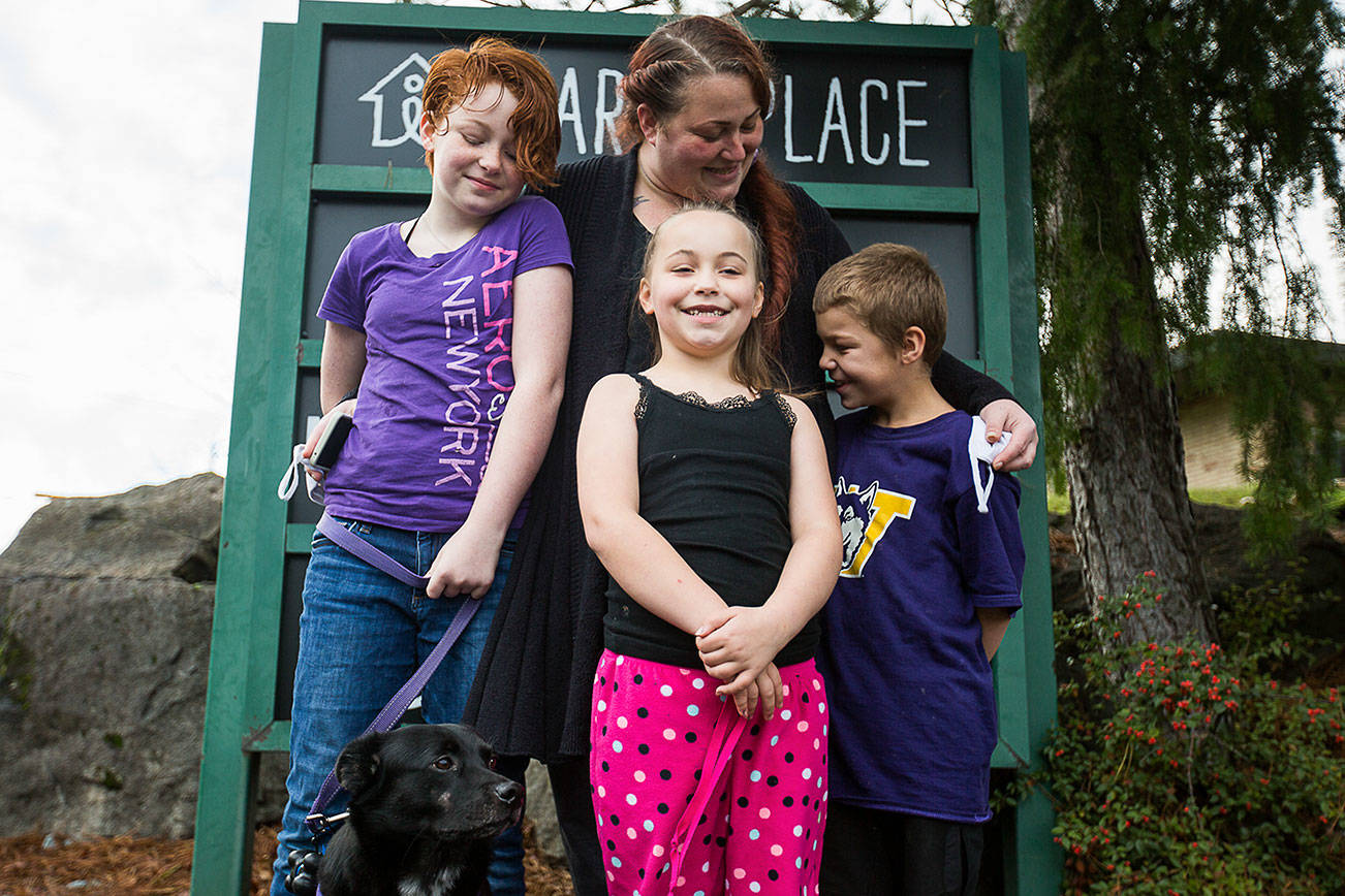 Julie Copeland, center, with her daughters Lillian, 11, Naomi, 7 and son, Michah, 9 with their dog Pippin, 3, outside of Mary's Place on Thursday, Nov. 19, 2020 in Burien, Wa. (Olivia Vanni / The Herald)