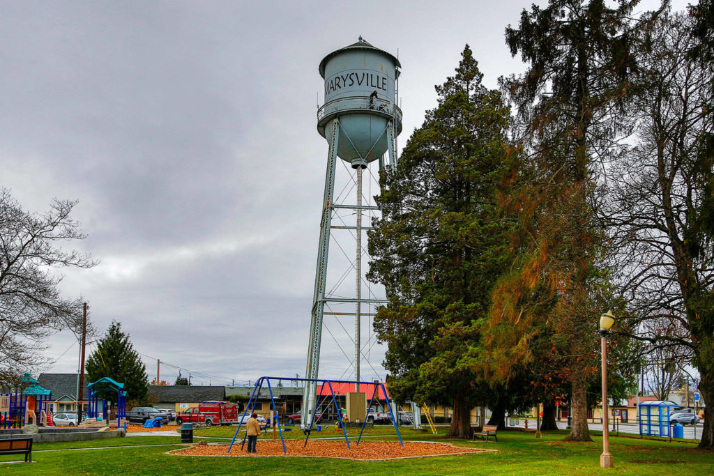 Marysville firefighters string lights on the Marysville water tower Friday. (Kevin Clark / The Herald) 
