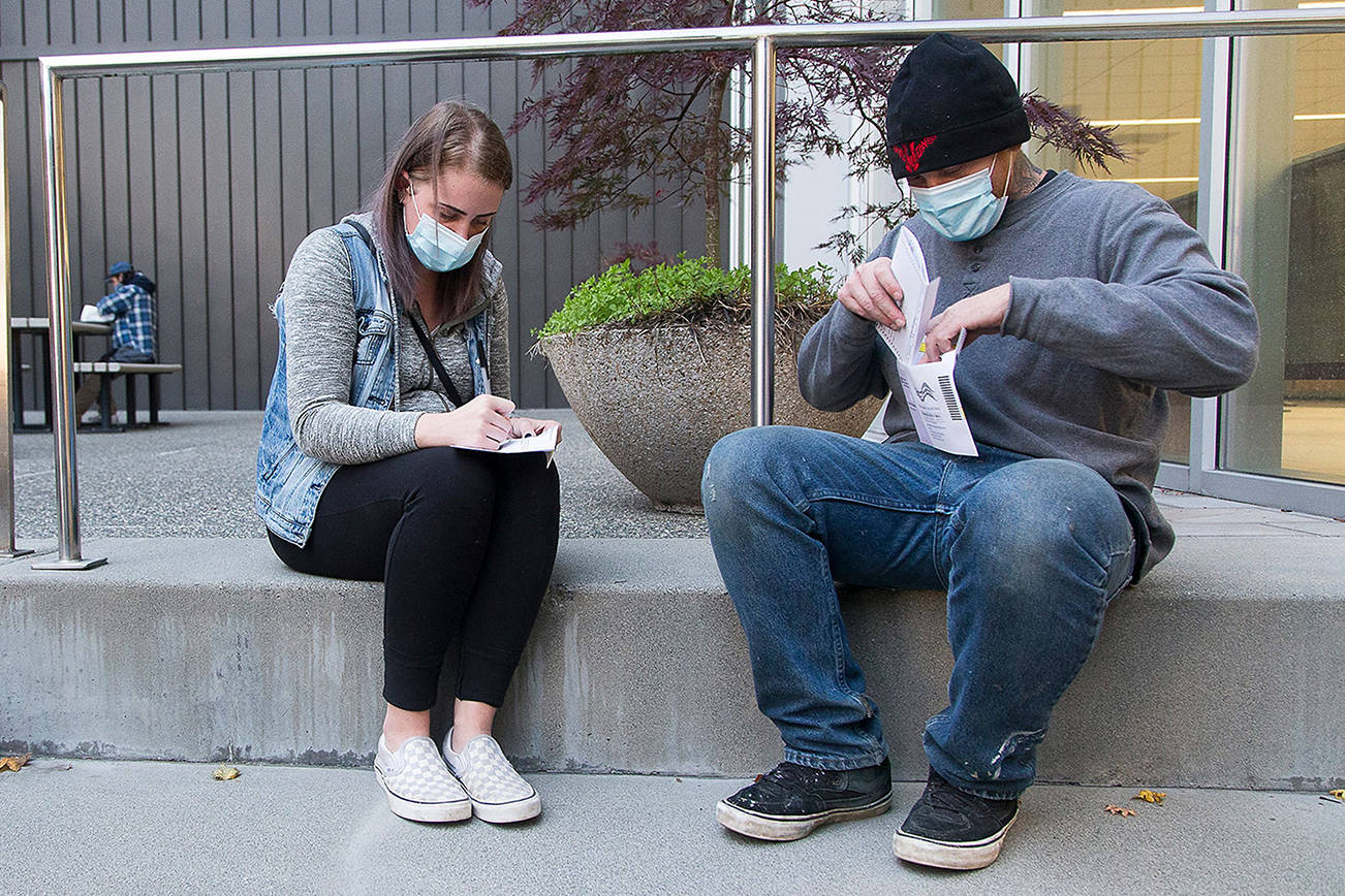 Voters Brie Roberts, 28, and Michael Woods, 30, vote for the first time at the Robert J. Drewel Administration Building on the Snohomsish County Campus on Monday, Nov. 2, 2020 in Everett, Washington.  (Andy Bronson / The Herald)