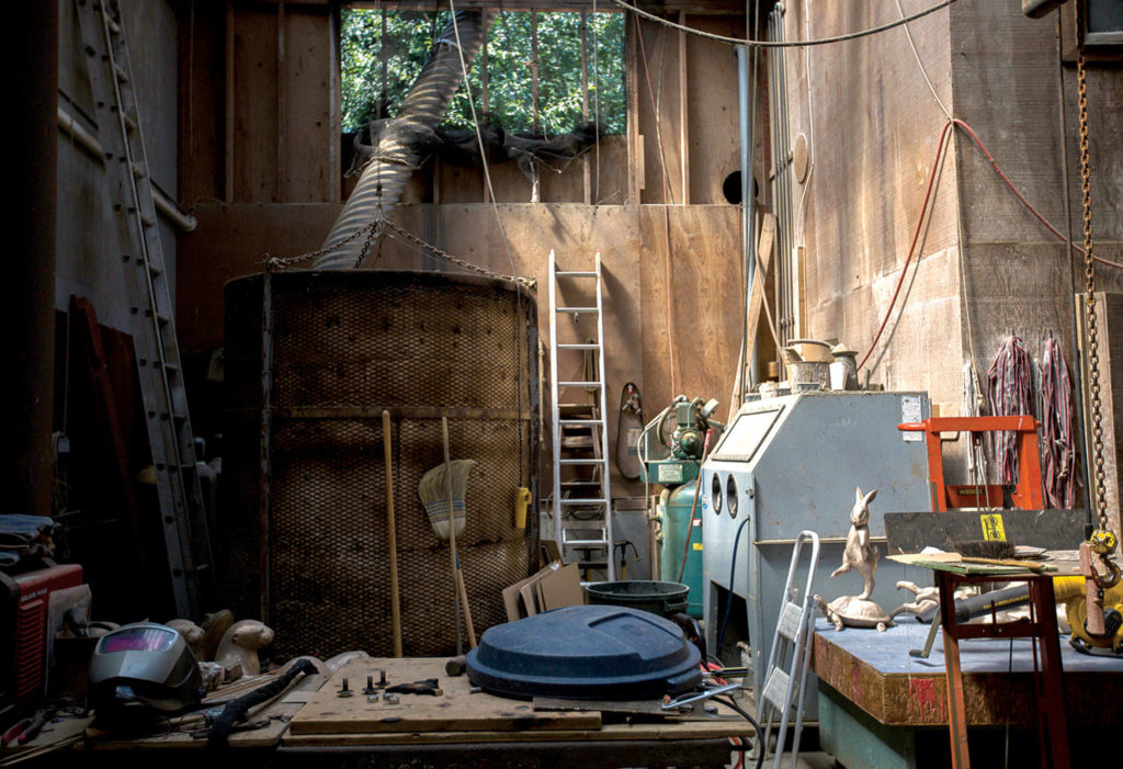 At far right, a statue of a rabbit dancing on a turtle sits on a workbench at Georgia Gerber’s home in Clinton. (Olivia Vanni / The Herald)
