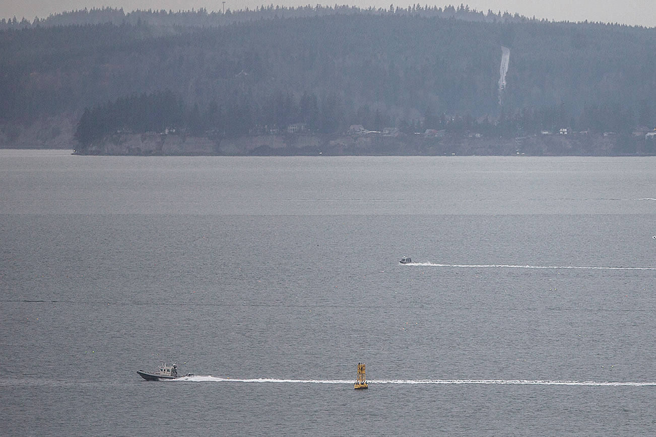 A police boat heads out across Possession Sound while the search for a Tulalip police officer missing from a capsized Tulalip fisheries boat continues on Wednesday, Nov. 18, 2020 in Everett, Wa. (Olivia Vanni / The Herald)