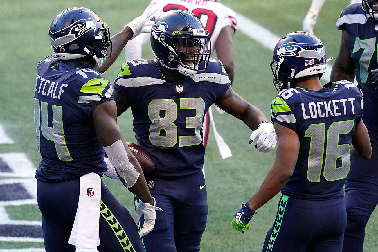 Seattle Seahawks wide receiver David Moore (83) celebrates with DK Metcalf, left, and Tyler Lockett (16), after Moore scored a touchdown against the San Francisco 49ers during the second half of an NFL football game, Sunday, Nov. 1, 2020, in Seattle. (AP Photo/Elaine Thompson)