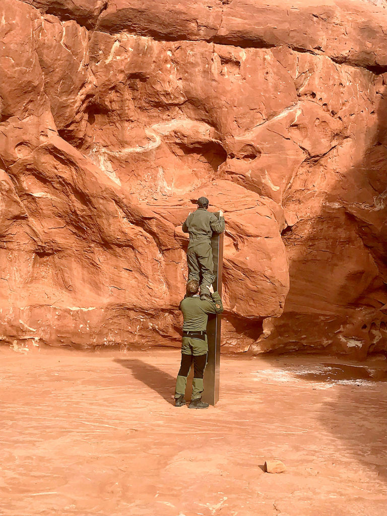 Utah state workers inspect a metal monolith in the ground in a remote area of red rock Nov. 18 in Utah. The mysterious silver monolith found in the Utah desert has disappeared less than 10 days after it was spotted by wildlife biologists performing a helicopter survey of bighorn sheep, federal officials and witnesses said. The Bureau of Land Management said it had received credible reports that the three-sided stainless steel structure was removed on Nov. 27. (Utah Department of Public Safety via AP, File)
