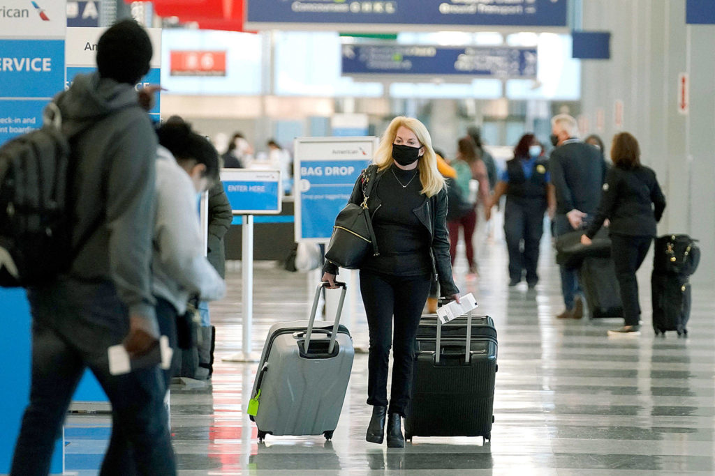 A traveler wears a mask Sunday while walking through Terminal 3 at O’Hare International Airport in Chicago. Friday’s total of new cases is the next-to-lowest daily number in the past 12 days, but Illinois state officials are bracing for another surge after many people around the country traveled for Thanksgiving and celebrated with family and friends. (AP Photo/Nam Y. Huh)
