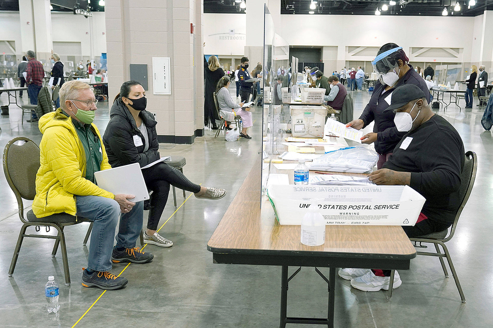 Election workers, right, verify ballots Nov. 20 as recount observers, left, watch during a Milwaukee hand recount of presidential votes at the Wisconsin Center in Milwaukee. Wisconsin finished a partial recount of its presidential results on Sunday, confirming Democrat Joe Biden’s victory over President Donald Trump in the key battleground state. Trump vowed to challenge the outcome in court. (AP Photo/Nam Y. Huh)