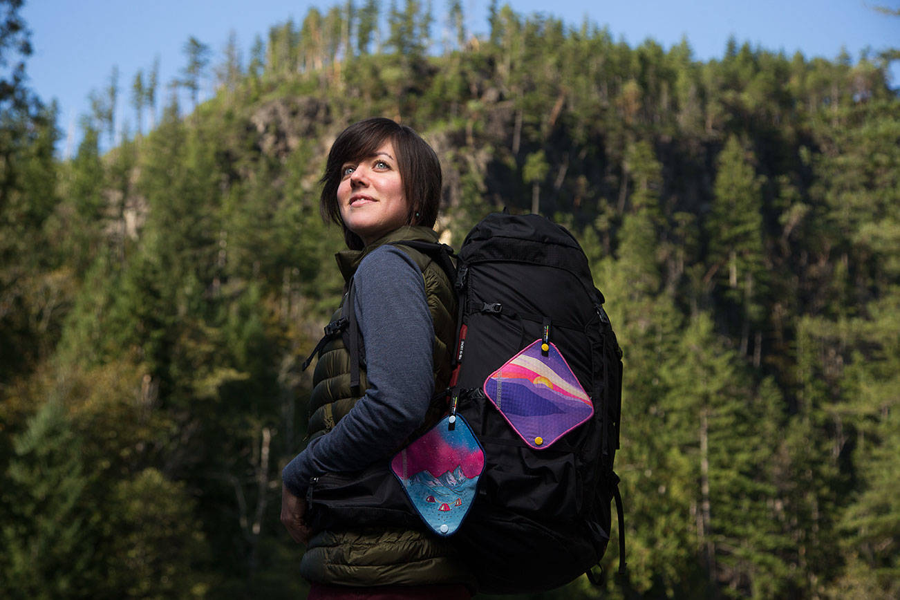 Anastasia Allison poses with samples of her Kula Cloth, a pee cloth for women to use outdoors, near her home on Monday, Oct. 12, 2020 in Arlington, Washington. Allison's invention has caught the eye of outdoor retail giant REI and will being selling them in stores soon. (Andy Bronson / The Herald)