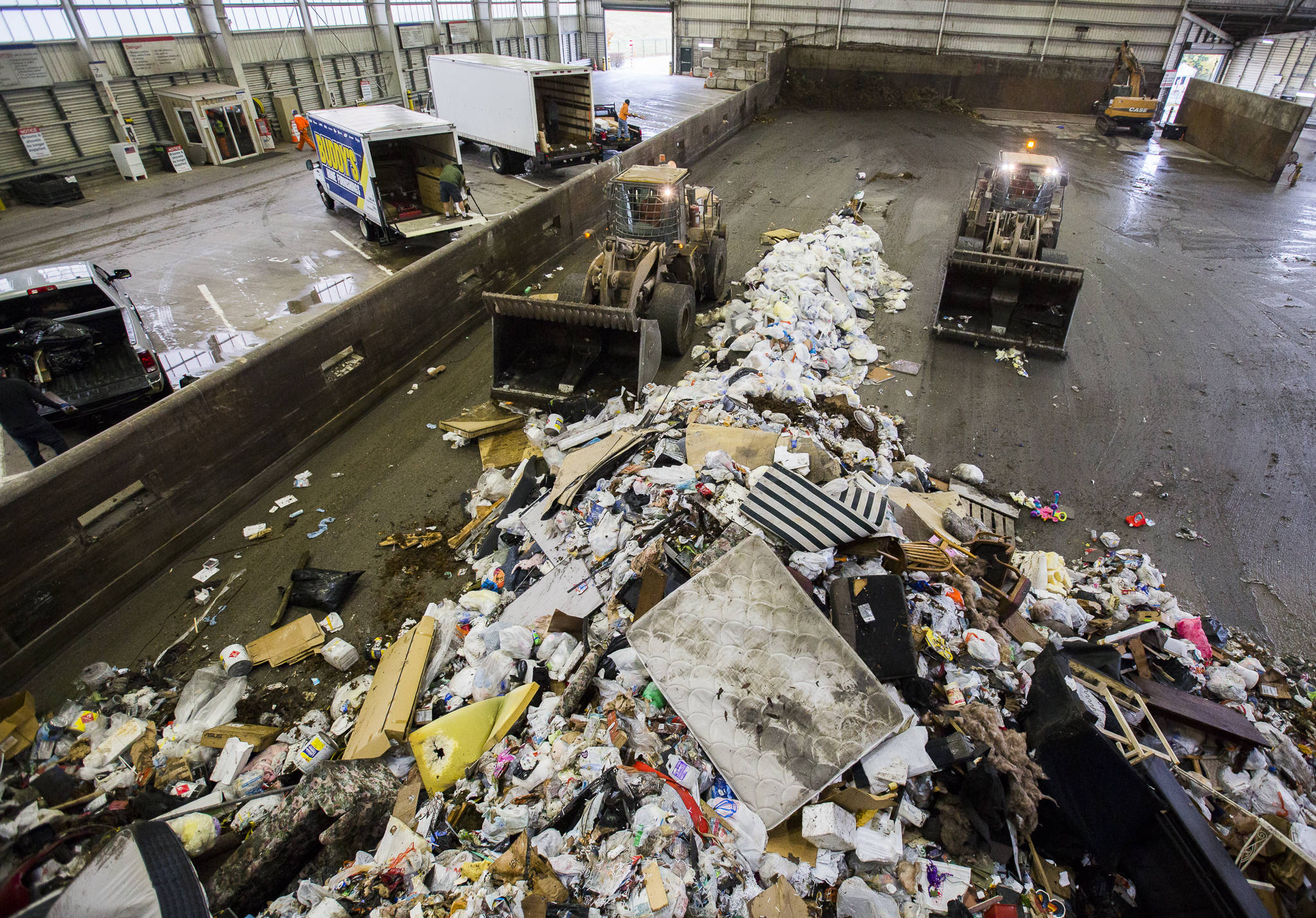 Front loaders push trash forward into one of the compactors at the Airport Road Recycling & Transfer Station on Nov. 24 in Everett. (Olivia Vanni / The Herald)