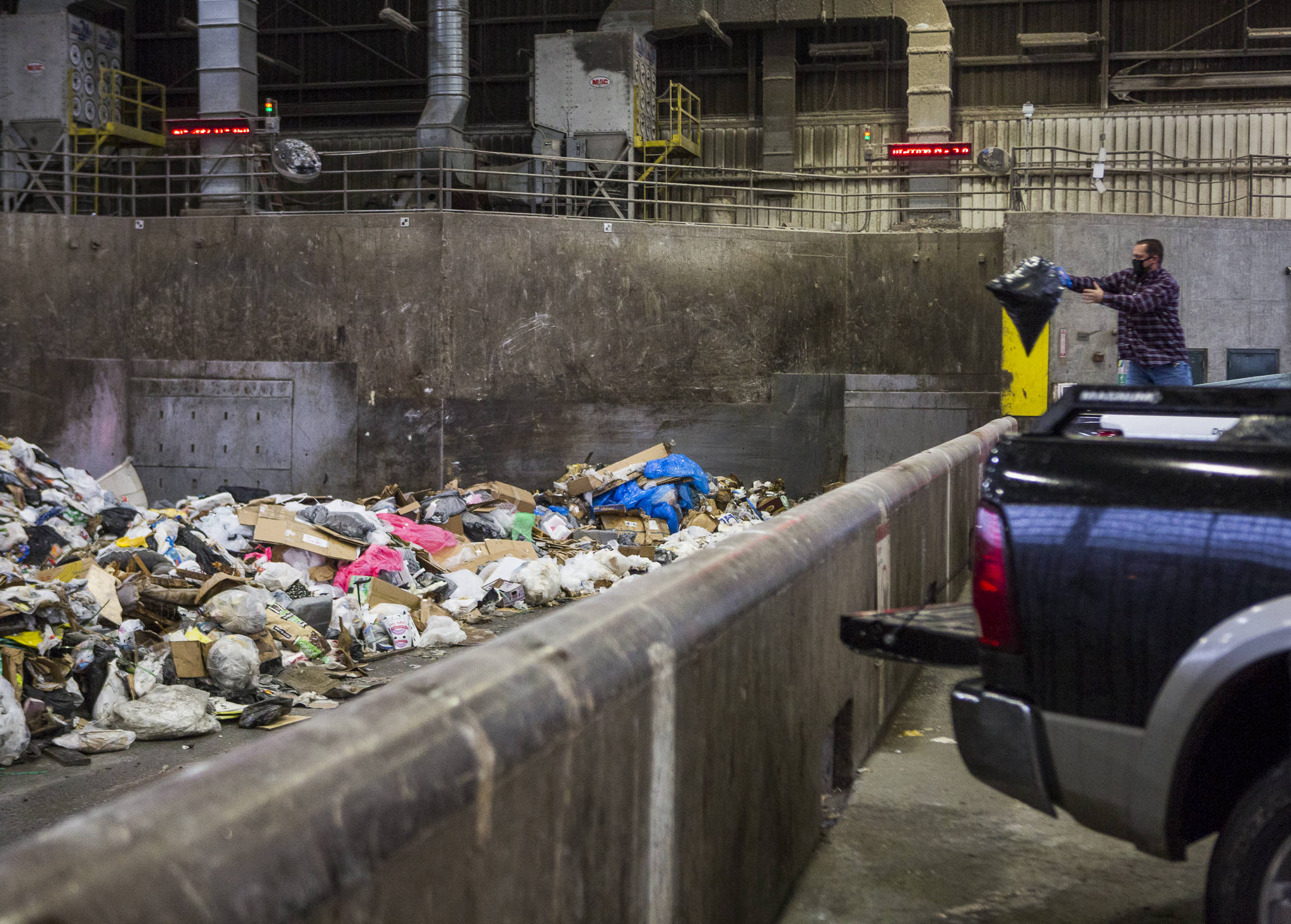 People throw their trash onto the tipping floor to be loaded into a compactor at the Airport Road Recycling & Transfer Station on Nov. 24 in Everett. (Olivia Vanni / The Herald)