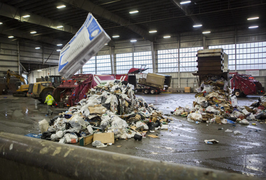 Garbage trucks dump trash onto the tipping floor at the Airport Road Recycling & Transfer Station on Nov. 24 in Everett. (Olivia Vanni / The Herald)
