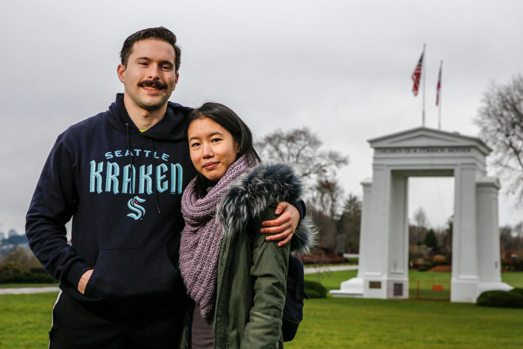 Bobby Warwick, a U.S. citizen, and Sarah Foo, a Canadian citizen, in front of the Peace Arch in Blaine. (Kevin Clark / The Herald)
