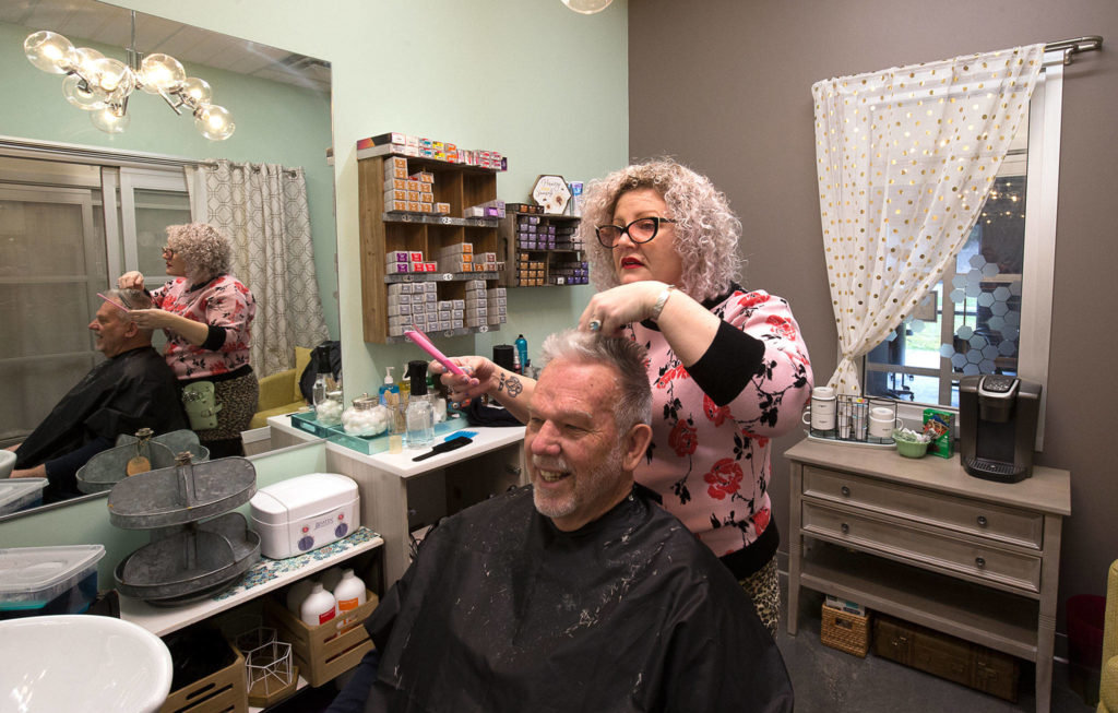 Shortly before the pandemic closed hair salons, Honeycomb Salon owner Julia Barbee gives Don Zimmerman a haircut in her studio inside Sola Salon Studios on March 13, 2020 in Mill Creek. The year’s top online viewed What’s Up column was in March, headlined “No more pretty hair or feet” with this photo. (Andy Bronson / The Herald)
