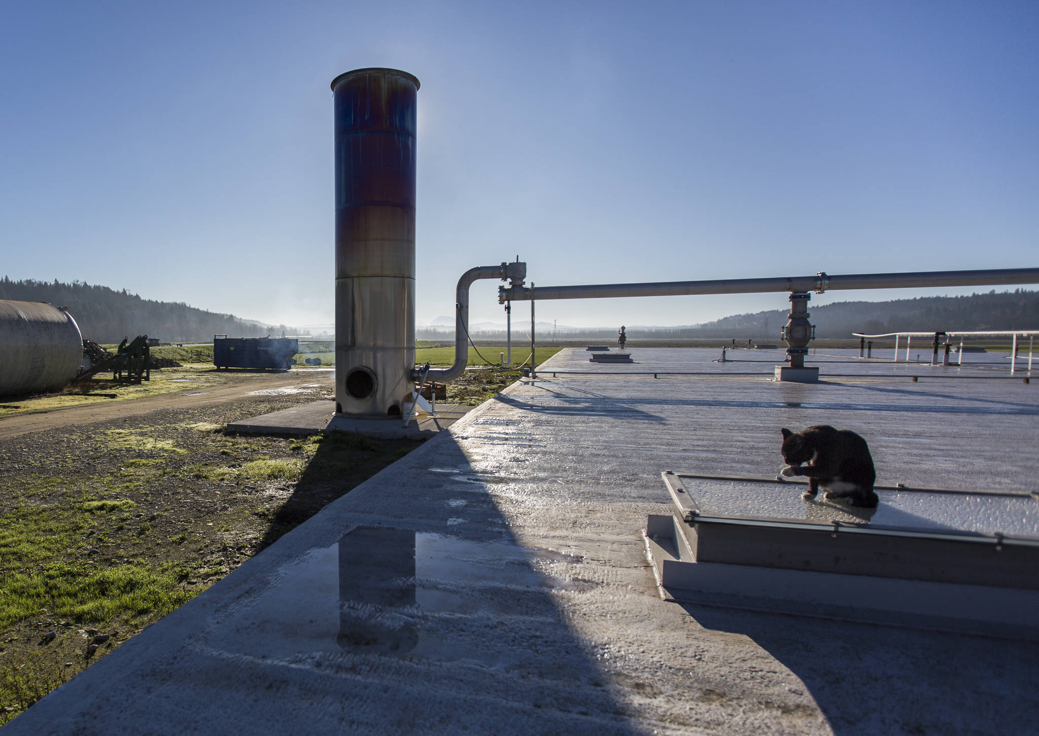 The anaerobic digester’s flare, where excess gas is combusted in Monroe, casts a shadow over the digester. (Olivia Vanni / The Herald)