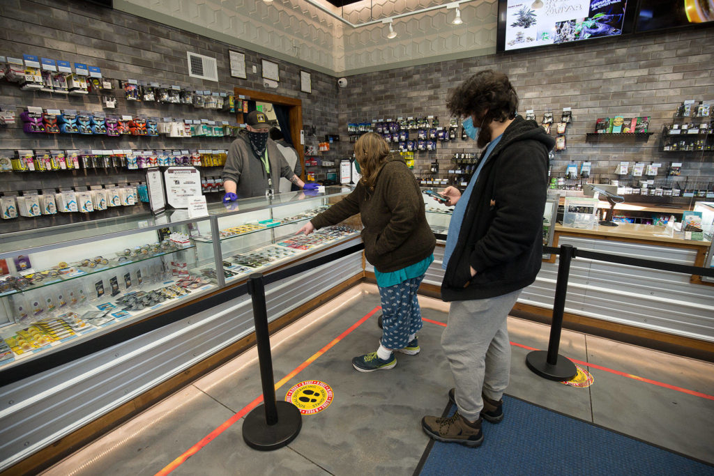 Amethyst Skeels and Alexander Walsh pick out cannabis products at Kushman’s Everett Cannabis Dispensary on Evergreen Way on Tuesday. (Andy Bronson / The Herald)
