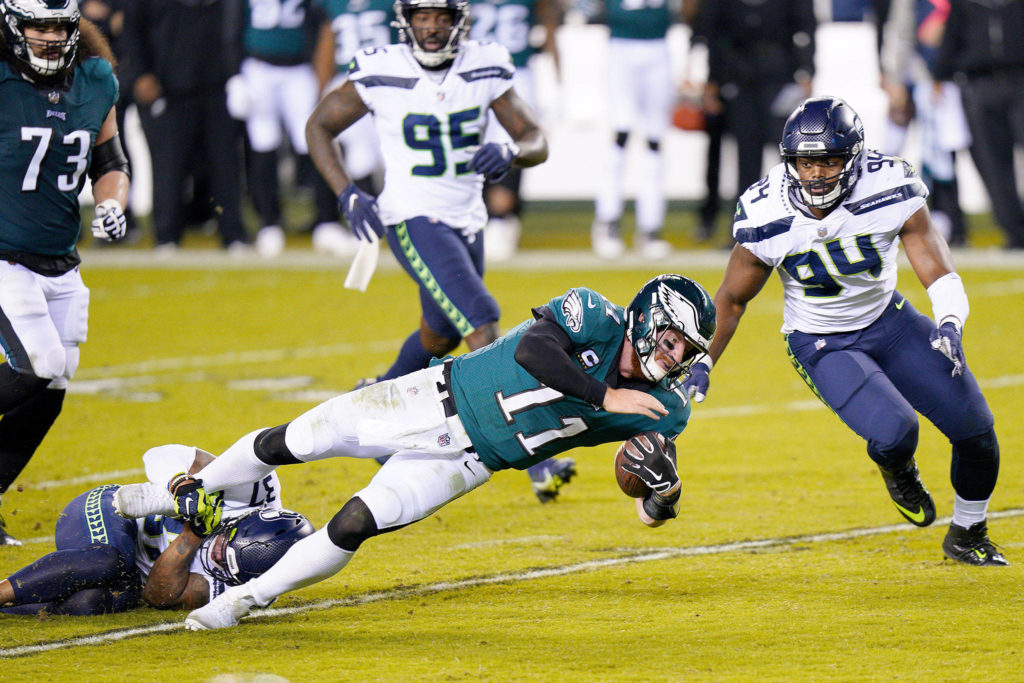 The Philadelphia Eagles’ Carson Wentz (11) is tackled by Seattle Seahawks’ Quandre Diggs (37) Monday in Philadelphia. (Chris Szagola / Associated Press)
