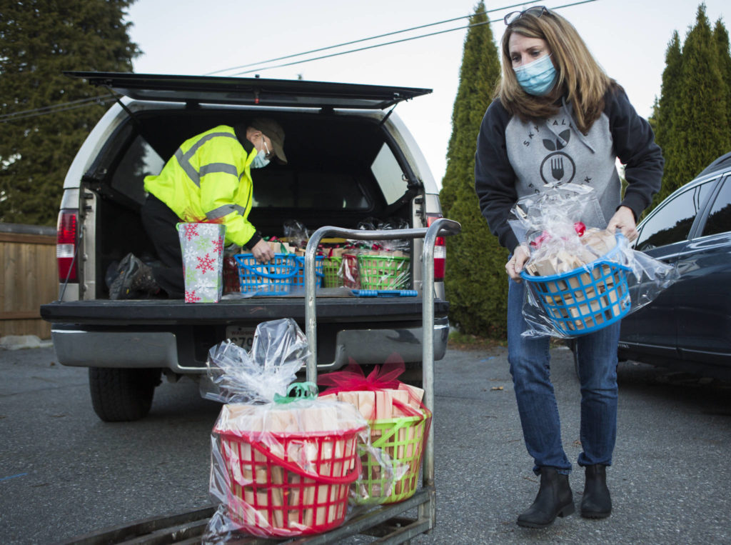 Sky Valley Food Bank Executive Director Cindy Chessie helps unload Jon Wilson’s toy block donations on Wednesday in Monroe. (Olivia Vanni / The Herald)
