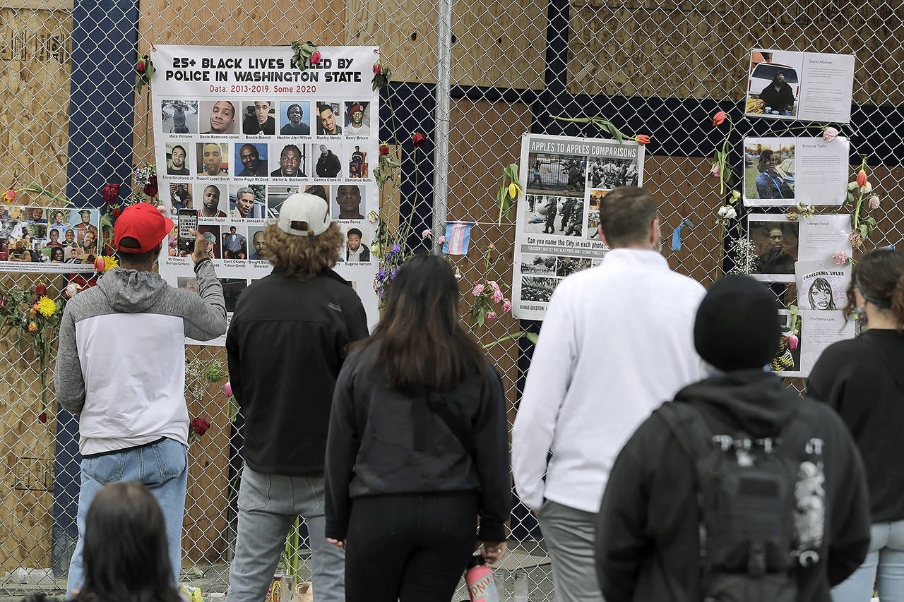 Visitors view photos of people who were killed by police in Washington State and elsewhere, June 16, inside what was called the Capitol Hill Occupied Protest zone in Seattle. (AP Photo/Ted S. Warren, file)