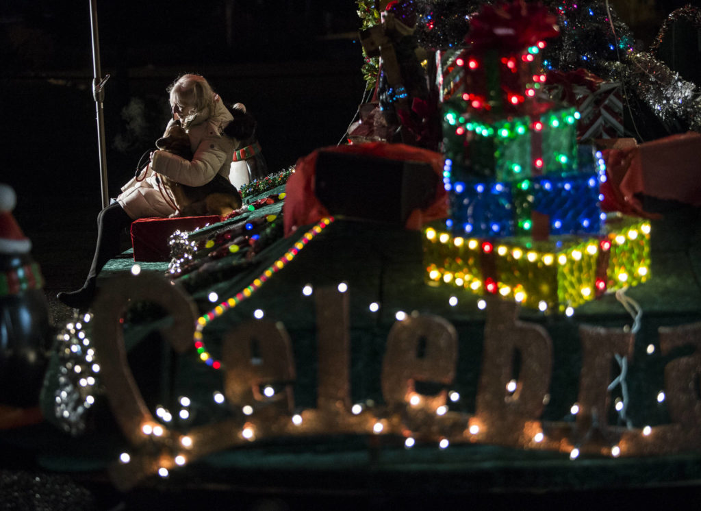 People take photographs with Santa Claus, who is set up on a festival float, Thursday in Marysville. (Olivia Vanni / The Herald)
