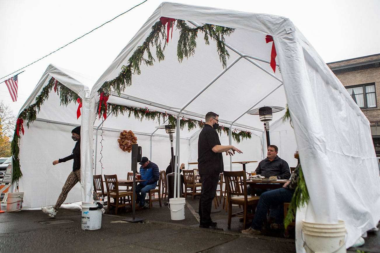 The Oxford Saloon owner Craig Swanson takes the orders of customers dinning outdoors along First Street on Wednesday, Dec. 9, 2020 in Snohomish, Wa. (Olivia Vanni / The Herald)