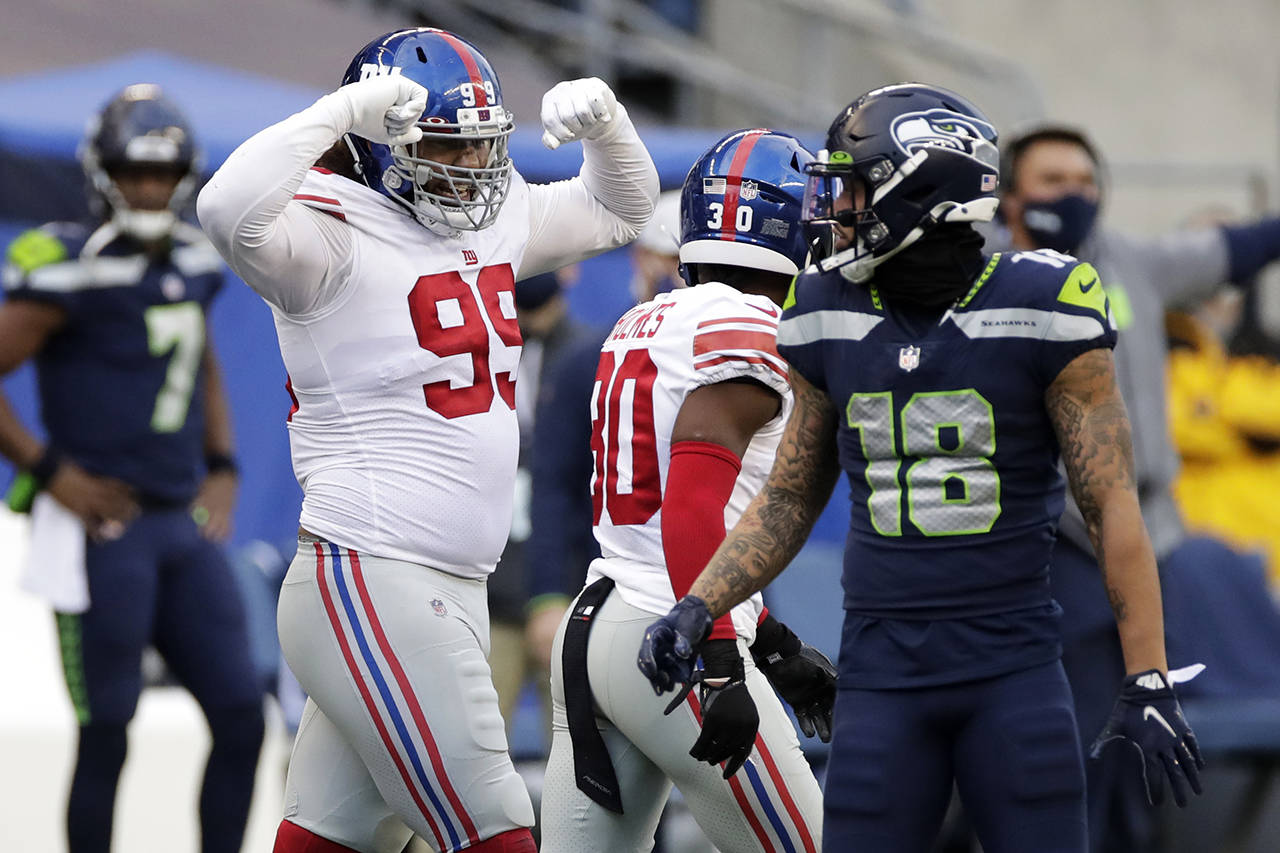 New York Giants defensive end Leonard Williams (left) reacts next to Seattle Seahawks wide receiver Freddie Swain (18) after a play during the second half of Sunday’s game in Seattle. (AP Photo/Larry Maurer)