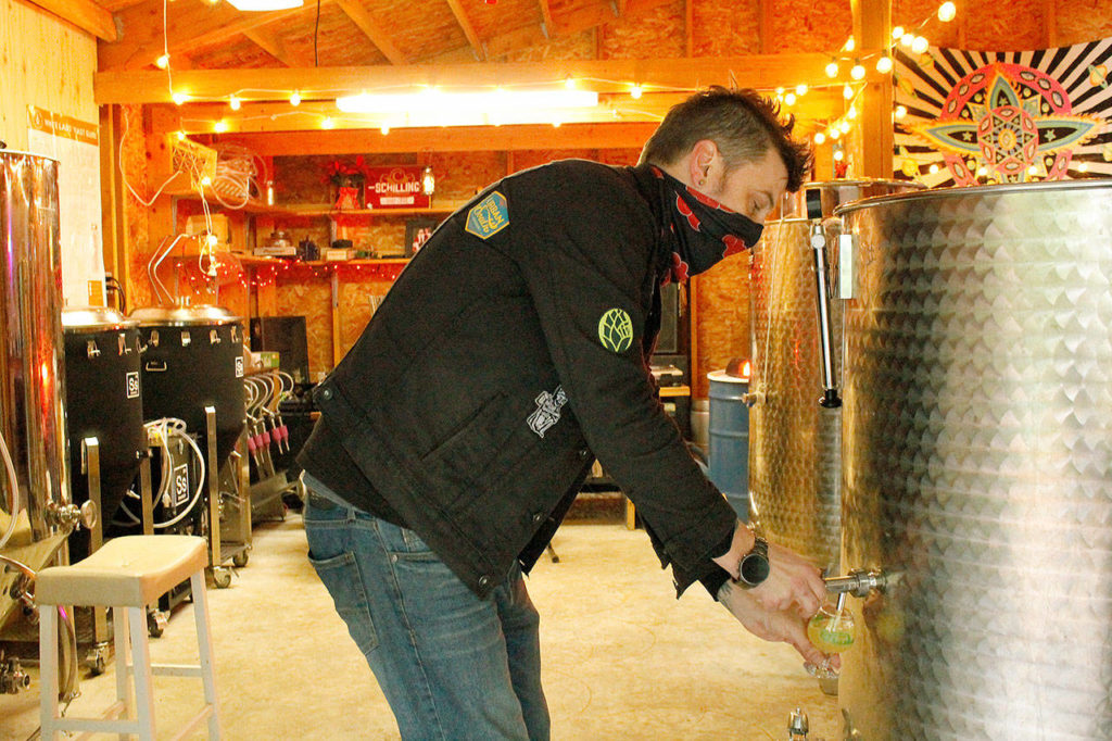 Christopher “CJ” Powell pours a glass of fresh-hop cider in the production room of his Misfit Island Cider Co. near Langley. Powell said he hopes to open a tasting room this winter. (Kira Erickson / South Whidbey Record).
