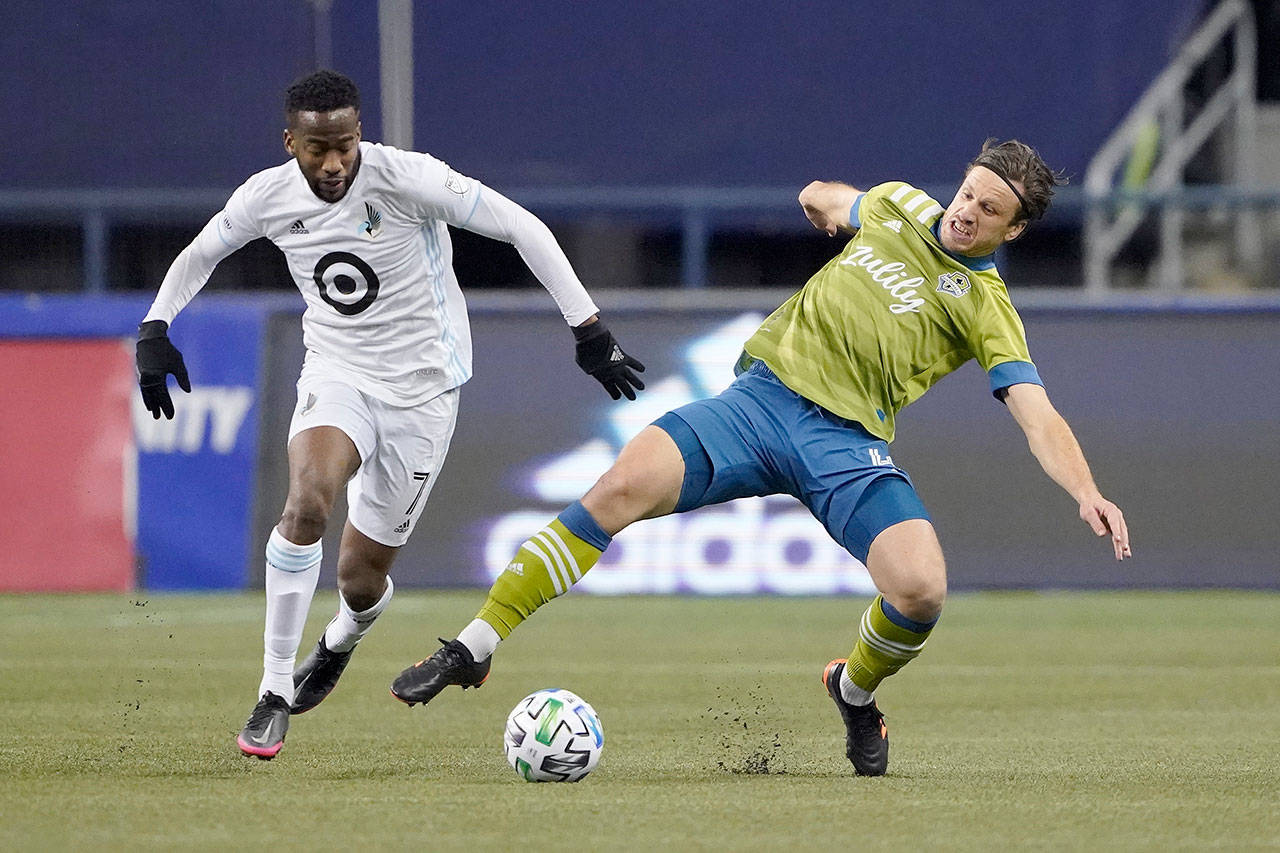 Minnesota United midfielder Kevin Molino (left) and Seattle Sounders midfielder Gustav Svensson vie for the ball during the second half of an MLS playoff Western Conference final soccer match Monday in Seattle. (Ted S. Warren / Associated Press)