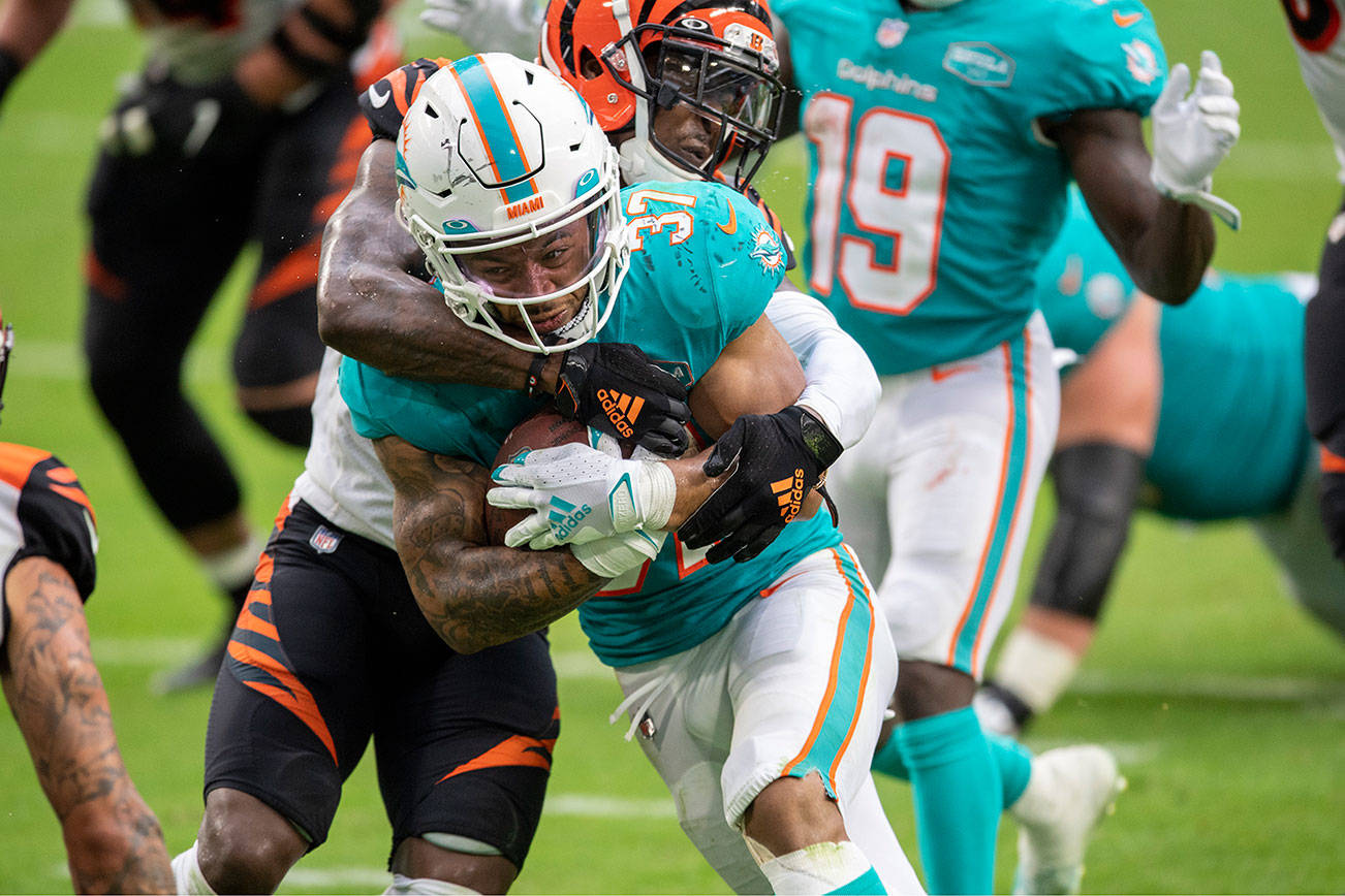 Miami Dolphins running back Myles Gaskin (37) runs with ball and is tackled by Cincinnati Bengals cornerback Mackensie Alexander (21) during an NFL football game, Sunday, DEC. 6, 2020, in Miami Gardens, Fla. (AP Photo/Doug Murray)