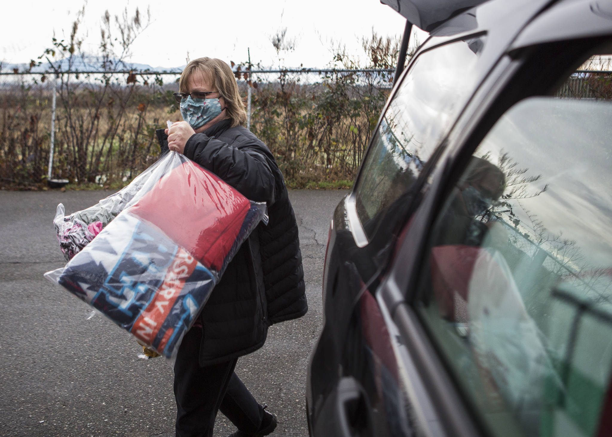 Tonja Jones unloads bags of donated coats outside the Everett Gospel Mission on Dec. 10. (Olivia Vanni / The Herald)