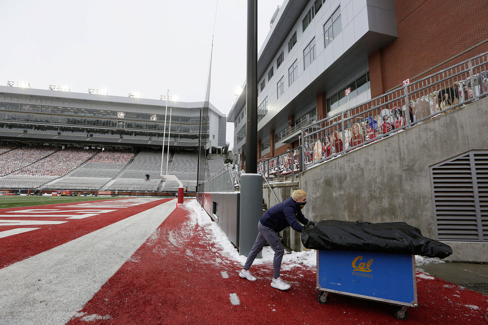 California student equipment manager Will O’Connor removes equipment from Martin Stadium after Saturday’s game between Washington State and California in Pullman was canceled because of a case of COVID-19 on the Golden Bears. (AP Photo/Young Kwak)
