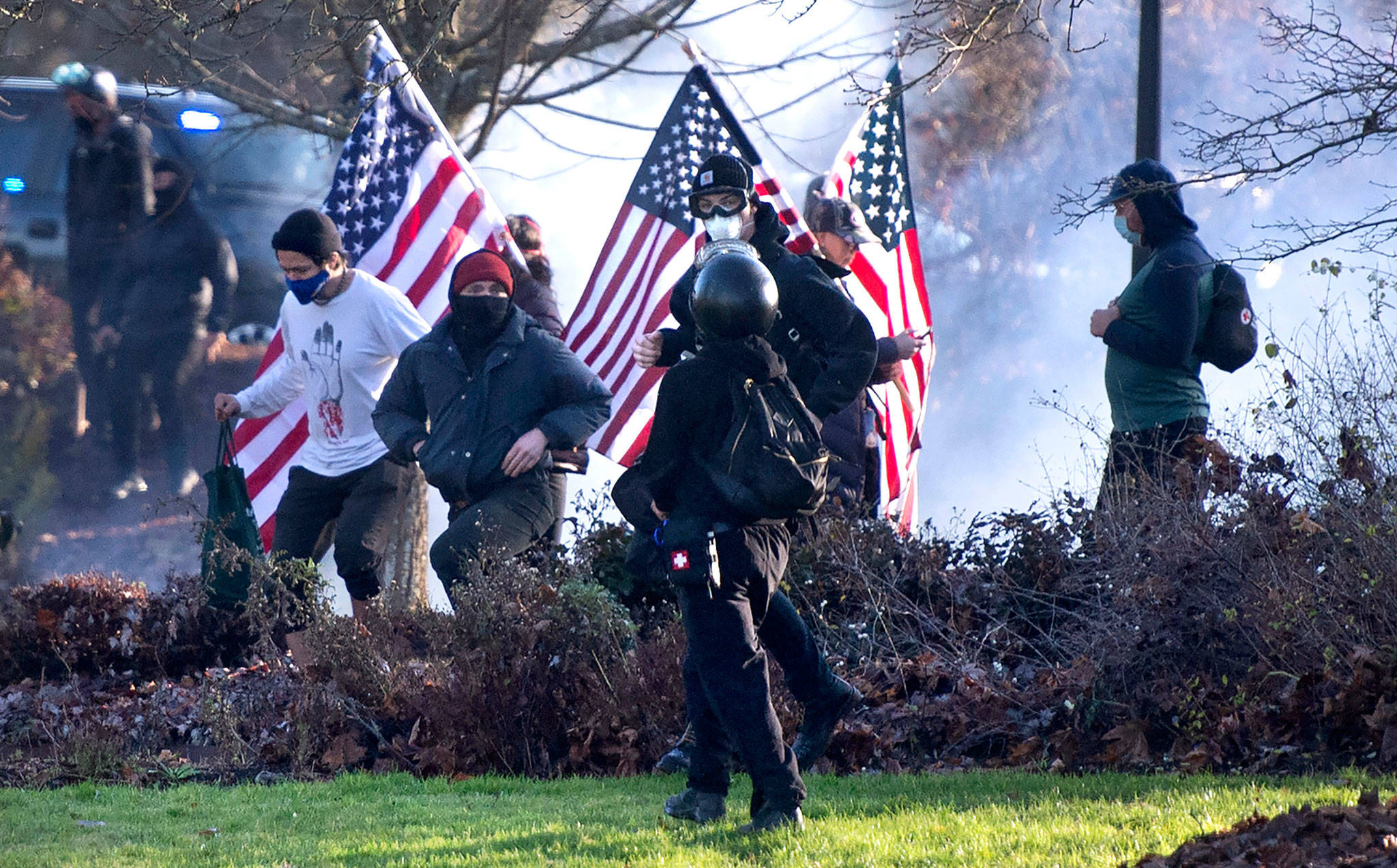 Protesters clashed at the state Capitol Campus in Olympia on Saturday. Police in Olympia declared a riot early Saturday afternoon and arrested at least one person as groups with different points of view held simultaneous protests. (The Olympian via AP)