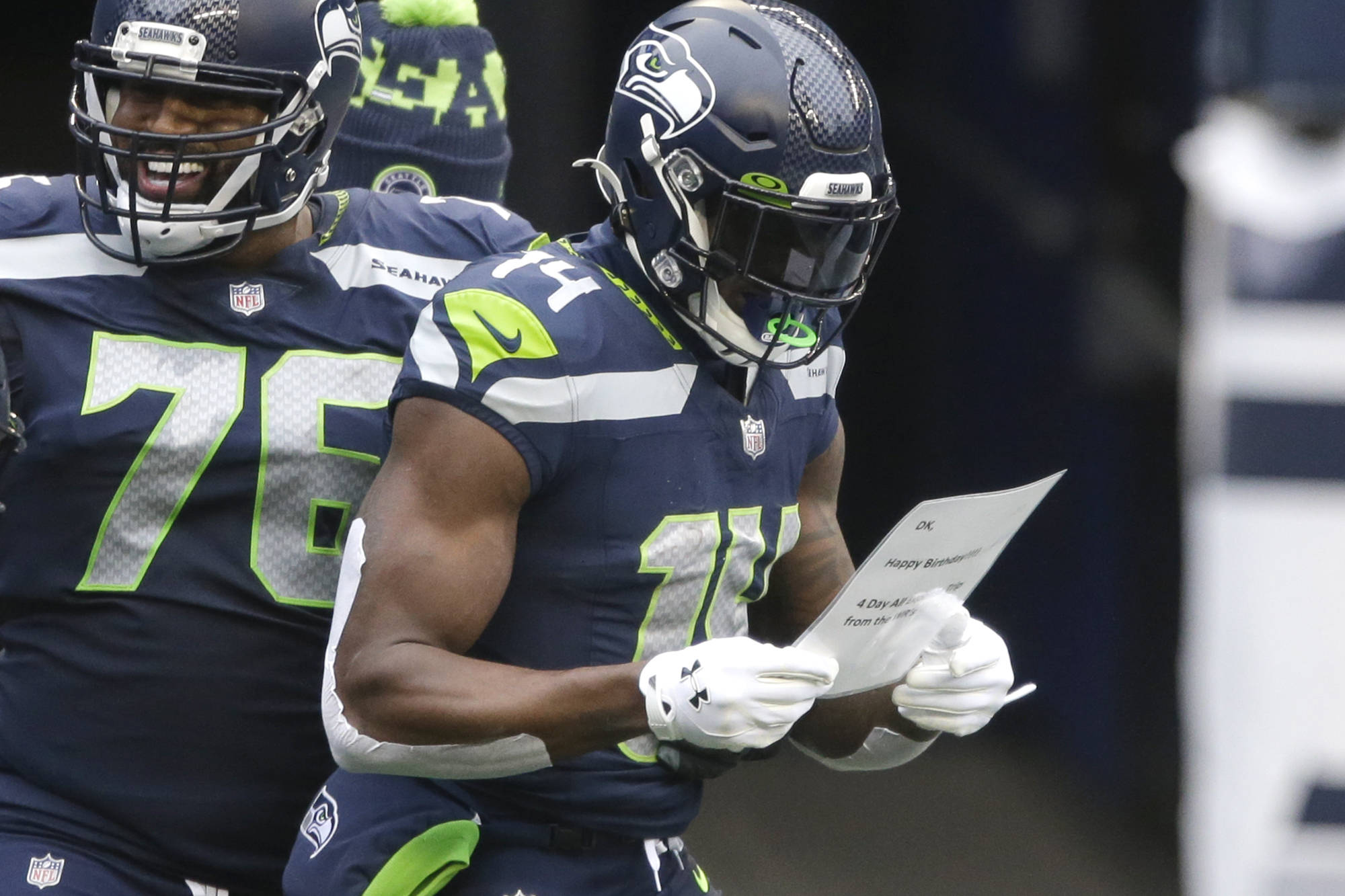Seattle Seahawks wide receiver DK Metcalf reads a birthday note handed him by his teammates after he scored a touchdown against the New York Jets during the first half Sunday at Lumen Field. (AP Photo/Lindsey Wasson)