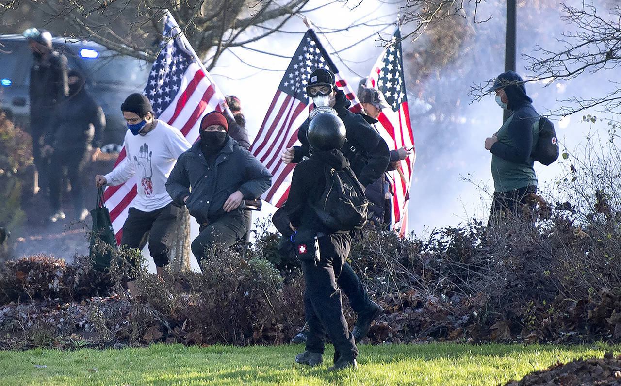 Supporters of President Donald Trump and antifa supporters clashed with Washington state police on the state Capitol Campus in Olympia on Saturday. (The Olympian via AP)