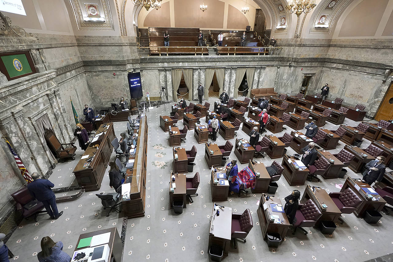 Members of Washington’s Electoral College and other officials stand for the Pledge of Allegiance before casting their votes in the Senate Chamber at the state Capitol in Olympia on Monday. (AP Photo/Ted S. Warren)