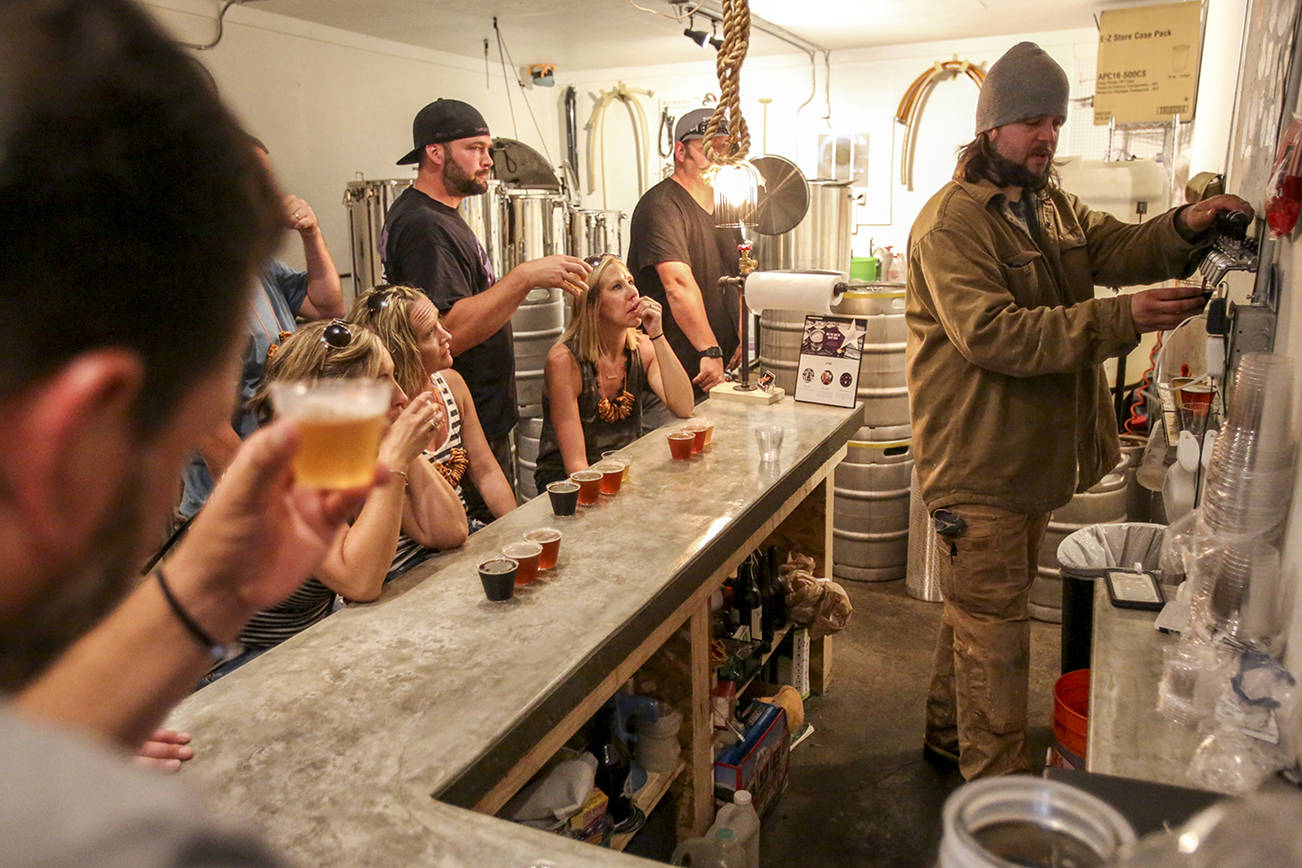 Greg Krsak, owner and operator of Scrappy Punk Brewery pours samples Saturday afternoon during the inaugural Soho Brew Tour in Snohomish on June 24, 2017.  (Kevin Clark / The Herald)