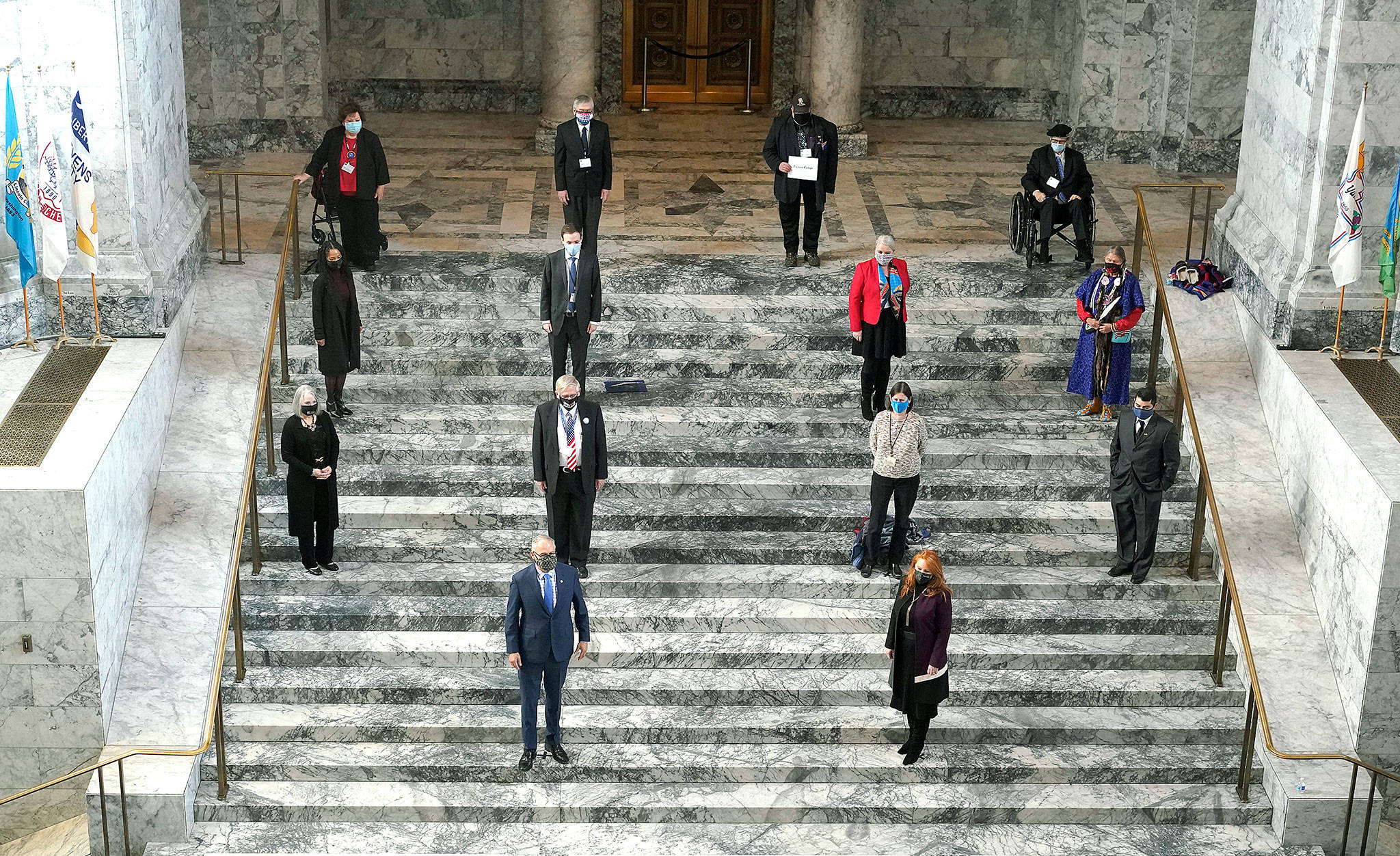 Members of Washington’s Electoral College pose for a socially distanced photo along with Gov. Jay Inslee (front row, left) and Secretary of State Kim Wyman (front row right) after they cast their votes at the state Capitol in Olympia on Monday. (AP Photo/Ted S. Warren)