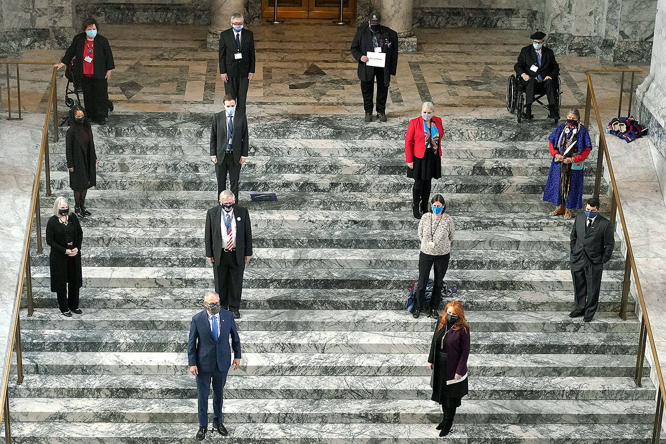 Members of Washington's Electoral College pose for a socially distanced photo along with Gov. Jay Inslee, front row left, and Secretary of State Kim Wyman, front row right, after they cast their votes at the state Capitol in Olympia, Wash., Monday, Dec. 14, 2020. (AP Photo/Ted S. Warren)