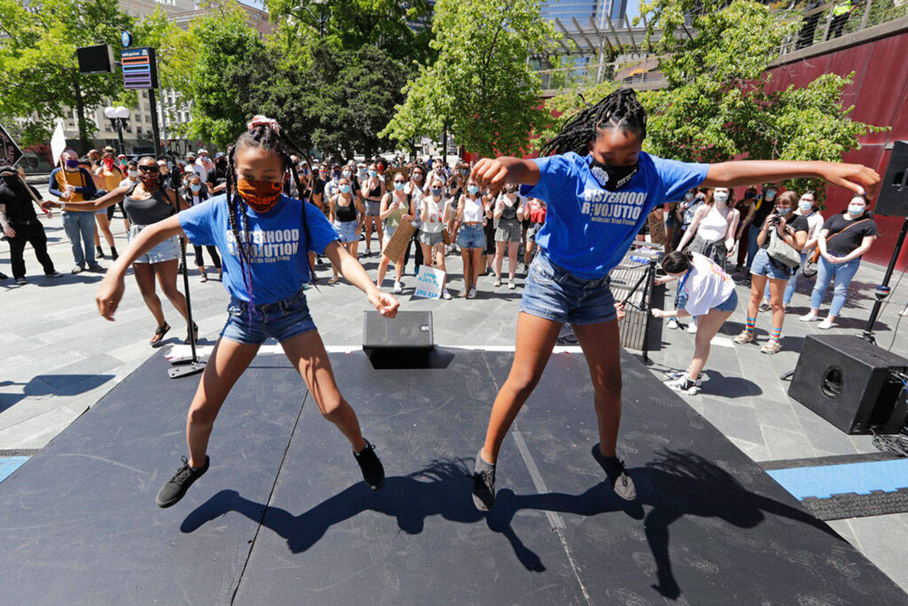 Keaira Johnson (left) and Cedella Dean of Northside Step Team, dance in front of Seattle City Hall at a protest led by youth activists demanding racial, climate, economic, worker and social justice July 20. The demonstration follows other protests over the death of George Floyd, a Black man who was killed in police custody in Minneapolis. Elaine Thompson / Associated Press file photo)