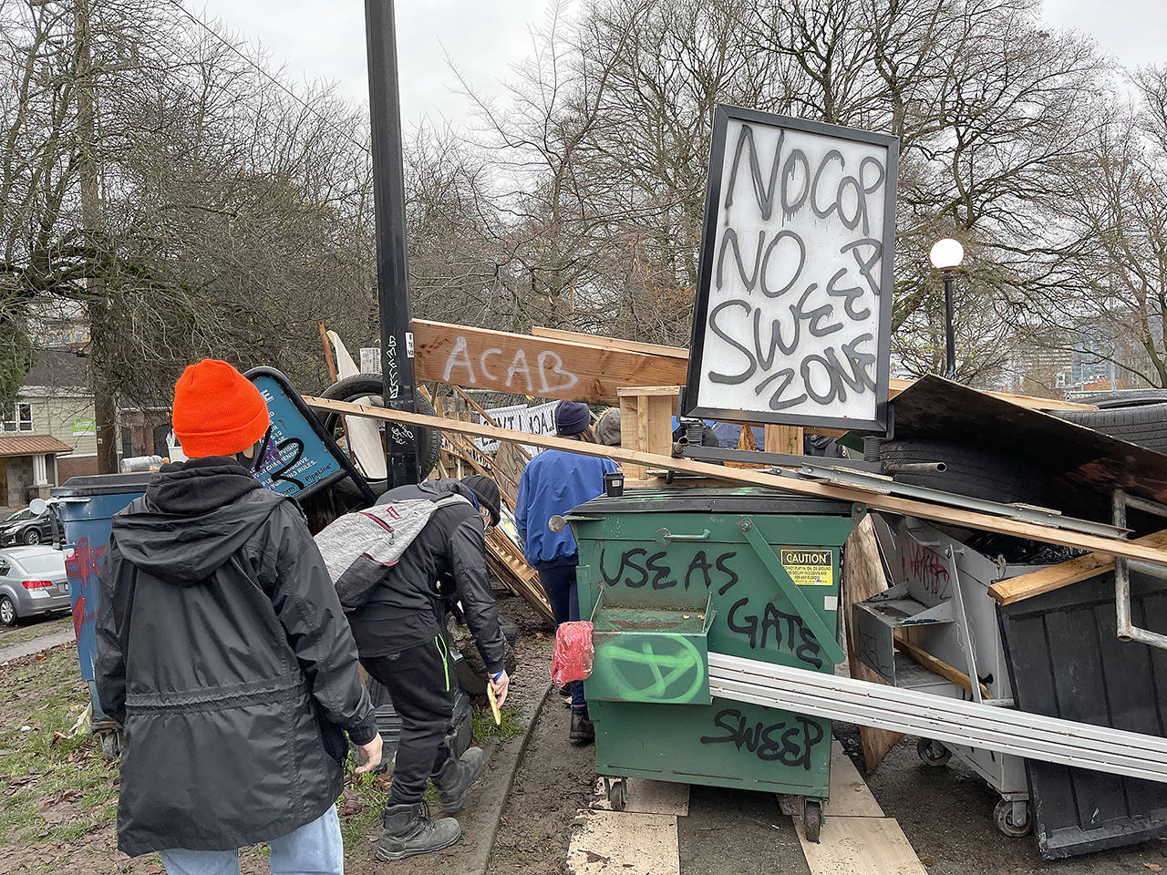 The homeless camp is completely encircled with debris and fencing blocking the City of Seattle’s sweep of the camp Cal Anderson Park, on Wednesday in Seattle. This is the only entrance to the area within the park. (Steve Ringman/The Seattle Times via AP)