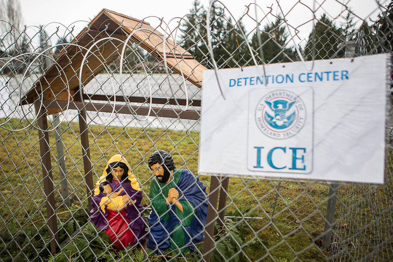 An ICE Detention Center sign hangs on the chainlink fence surrounding the nativity scene in front of the Edmonds Luther Church on Sunday, Dec. 20, 2020 in Edmonds, Wa. (Olivia Vanni / The Herald)