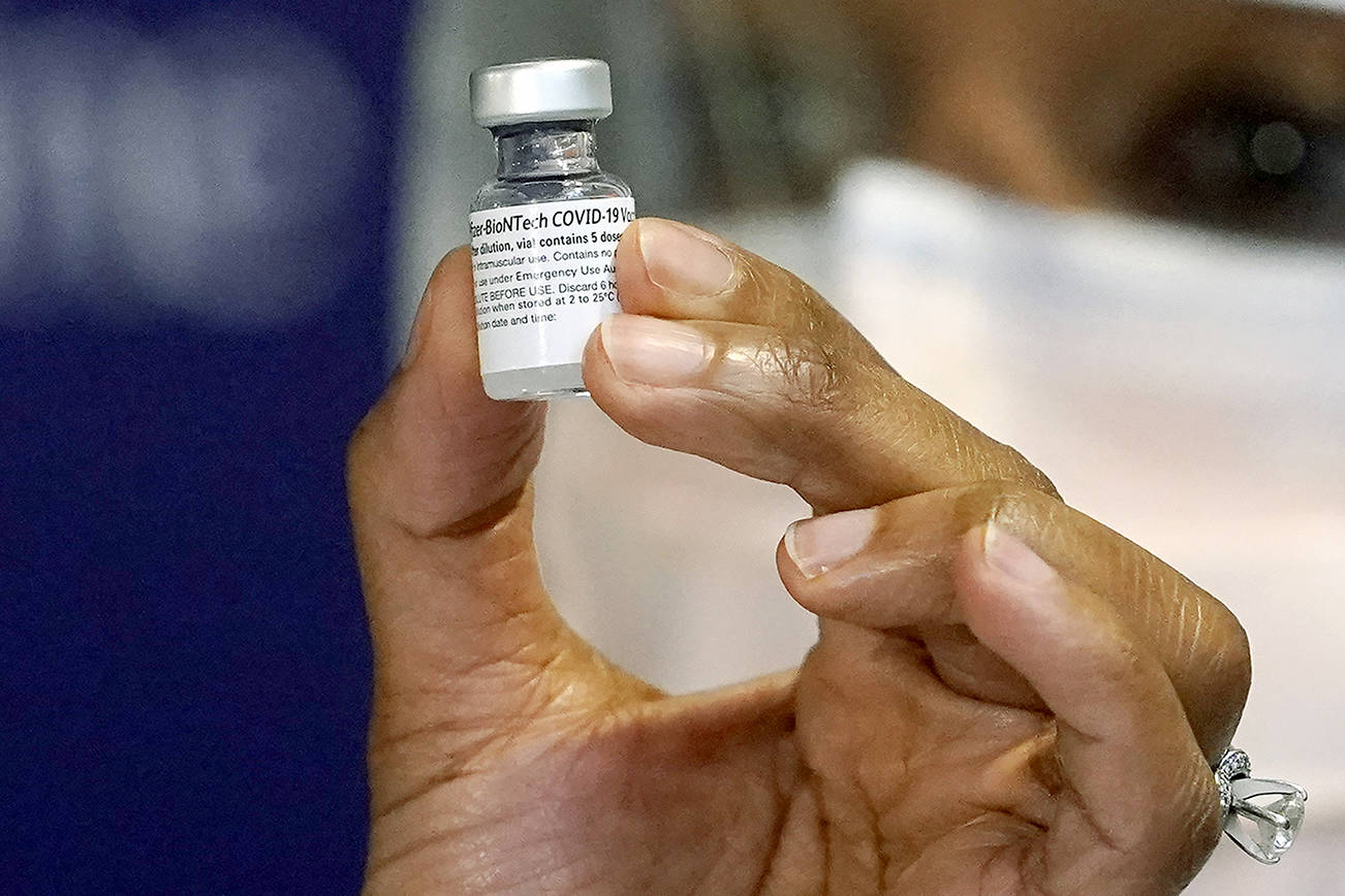 Pharmacist Fetiya Omer displays a vial of COVID-19 vaccination at UW Medicine, where they began staff vaccinations earlier, Tuesday, Dec. 15, 2020, in Seattle. (AP Photo/Elaine Thompson)