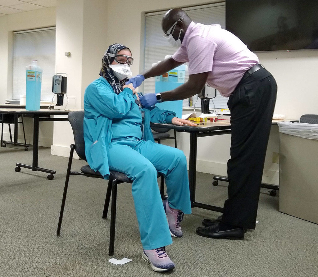Nurse Elizabeth Njie is vaccinated at Providence Regional Medical Center Everett on Friday. (Providence) 
